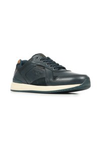 Zapatilla de cuero azul marino oscuro con una suela de goma blanca curvada, acentos texturizados, seis ojales y un pequeño logo en el costado.
