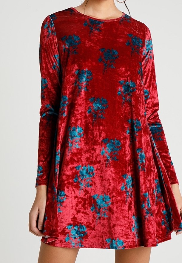 Robe longue en velours rouge à manches longues, avec une coupe décontractée, un col rond et des motifs floraux bleus. La texture douce renforce l'attrait visuel.