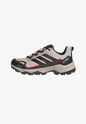 Jasnobeżowe i czarne buty trekkingowe Adidas Terrex z czarnymi paskami, różowymi akcentami, cholewką Gore-Tex oraz wytrzymałą podeszwą Lightmotion.