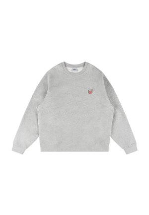 Szara bluza z okrągłym dekoltem, ściągaczami na mankietach oraz małym haftowanym logo w kształcie tarczy w kolorach czerwonym i niebieskim na lewej piersi.