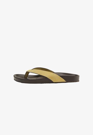 Brun klip-klap sandal med tyk beige ruskindrem, der krydser over foden, og tekstureret sål for bedre greb.