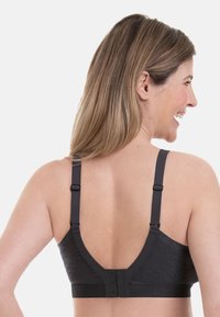 Svart blonde bralette med justerbare stropper, en dyp ryggdesign og en krok-og-løkke lukking. Teksturert stoff gir visuell interesse.