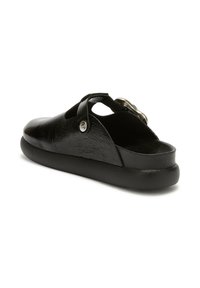 Scarpe slip-on nere con tomaia in pelle strutturata, open back e una cinghia decorativa con un accento metallico. Suola in gomma liscia.