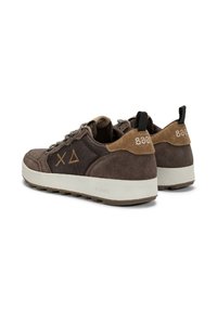 Sneaker casual in suede e tessuto marrone con suole bianche, linguette nere, lacci a fantasia e logo geometrico laterale, mostrati da un angolo posteriore.