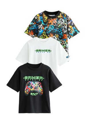 Three graphic t-shirts: black shirt with colorful game controller design, white shirt with "GAMER LEVEL UP" text, and multicolored patterned shirt.