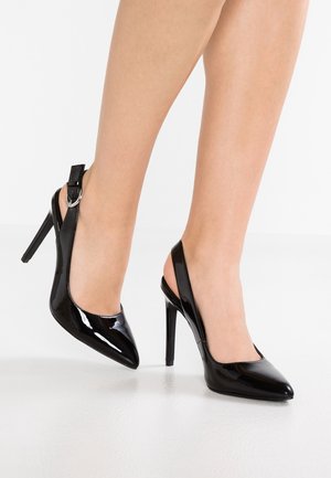 Czarne lakierowane czółenka na szpilce z wąskim noskiem, wysokim obcasem stiletto oraz paskiem wokół kostki z detalem w postaci srebrnej klamry.