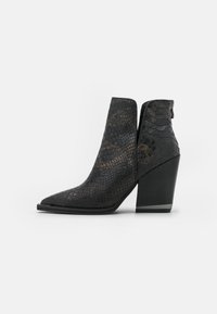 Botas negras hasta el tobillo con un patrón de piel de serpiente texturizado, punta afilada y un tacón alto y grueso. Cuenta con una cremallera lateral para el cierre.