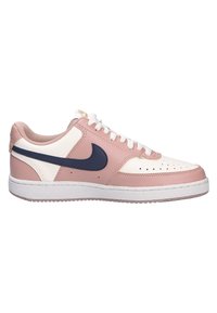 Sneakers Nike avec un dessus en cuir rose et blanc, un Swoosh bleu marine, un bout perforé et une semelle en caoutchouc blanc avec une traction texturée.