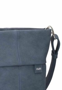 Borsa a spalla in pelle blu con superficie texturizzata, design con chiusura a pieghe in alto, tracolla regolabile e dettagli in metallo. Etichetta del marchio visibile.