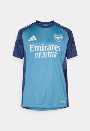 Målmandstrøje i teal og marineblå, lavet af åndbart stof. Udstyret med "Emirates" og "Arsenal" logoer, korte ærmer og kontrasterende skulderdetaljer.