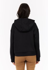 Zwarte cropped hoodie met lange mouwen en een capuchon met trekkoord. Soepele textuur, ontspannen pasvorm en naaddetails op de rug.