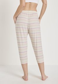Lichte, gestreepte loungebroeken in beige met roze en lichtblauwe lijnen, met een comfortabele elastische tailleband en zijzakken.