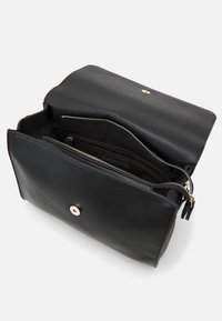 Borsa nera in pelle con zip superiore, dotata di chiusura a scatto dorata. L'interno presenta scomparti e una fodera morbida.