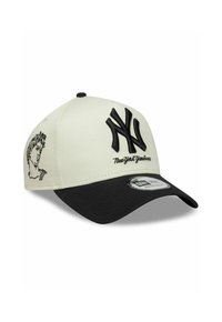 Casquette de baseball avec un devant crème et une visière noire. Présente un logo "NY" noir en relief et un motif imprimé d'une silhouette sur le côté.