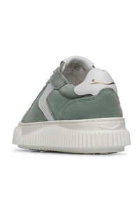 Sneaker verde in suede con dettagli bianchi e suola in gomma testurizzata. Presenta un design basso con un dettaglio del logo sul retro e un collare imbottito.