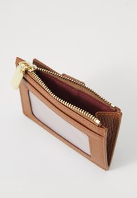 Brown leather wallet with a zip closure, smooth texture, and a clear ID window. Interior lined in burgundy fabric. Gold hardware accents.