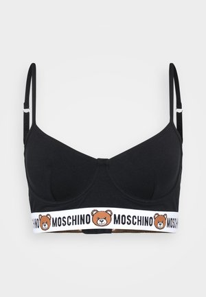 Bralette en coton noir avec de fines bretelles réglables, arborant une bande élastique blanche avec un logo d'ours et le texte "MOSCHINO" en bas.