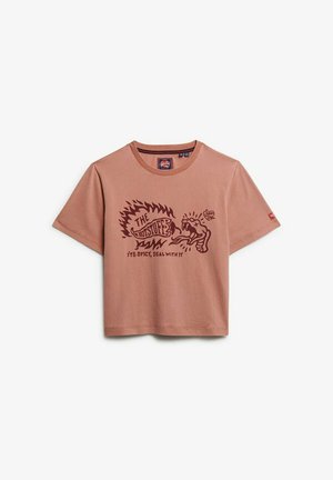 T-shirt à manches courtes de couleur rose, avec un graphisme représentant une main tenant un piment fort et le texte : "L'HOMME PIQUANT, C'EST ÉPICÉ, DÉBROUILLE-TOI."
