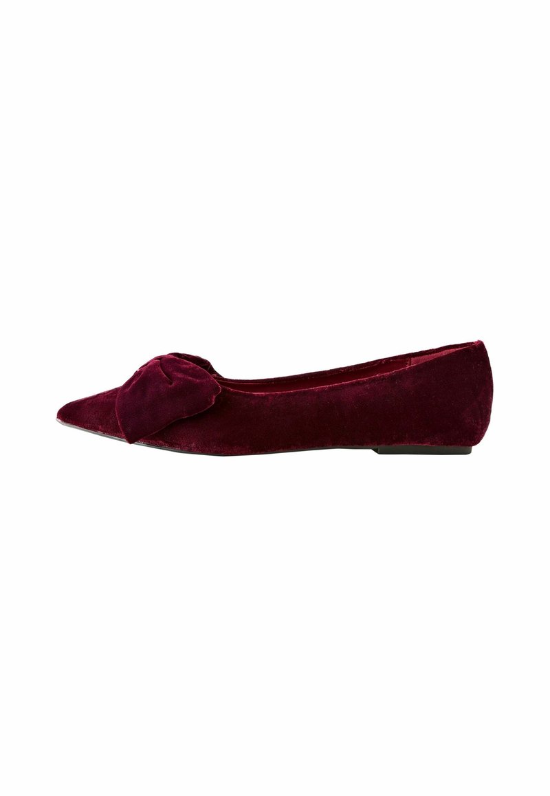 Chaussure plate en velours bordeaux pour femme avec bout pointu et grand nœud sur le dessus, vue de côté.