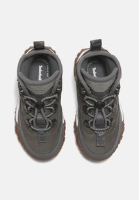 Šedé voděodolné boty s texturovaným svrškem, gumovou podrážkou a designem na šněrování. Obsahují poutko a logo uvnitř boty.