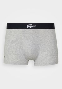 Boxers de algodón grises con una cinturilla elástica negra que presenta un logo blanco. Textura suave, diseño ajustado y longitud hasta mitad del muslo.