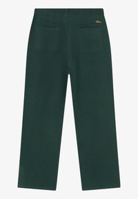 Ciemnozielone proste spodnie z elastycznym pasem i dwiema kieszeniami z tyłu, z małym haftem złotego logo nad prawą kieszenią.
