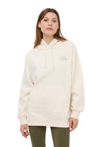 Kremowa bluza z kapturem, z kieszenią typu kangur, sznurkiem w kapturze oraz grafiką w kształcie gwiazdy z napisem "Bądź swoją własną gwiazdą" w jasnym beżu. Luźny krój.