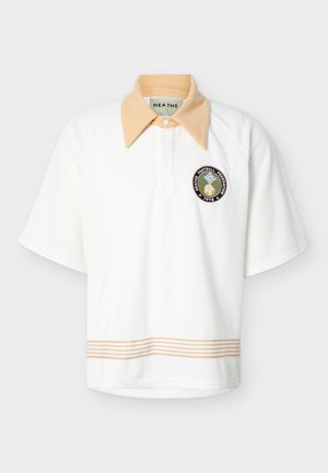 Biely polokošeľa s krátkym rukávom, béžovým špicatým golierom, béžovým pruhovaným lemom na spodnom okraji a kruhovou nášivkou s nápisom "HEATHE Football Federation 1978" na hrudi.