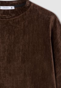 Top marrone in velluto a maniche lunghe con collo rotondo. Presenta una texture liscia e un'etichetta interna sul collo con la scritta "TERRANOVA" taglia S.