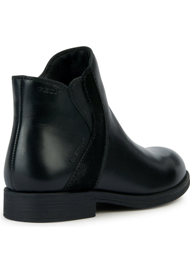 Stivale alla caviglia nero realizzato in pelle liscia con pannelli elastici sui lati, punta rotonda e una suola in gomma bassa e strutturata. Presenta un marchio in rilievo.