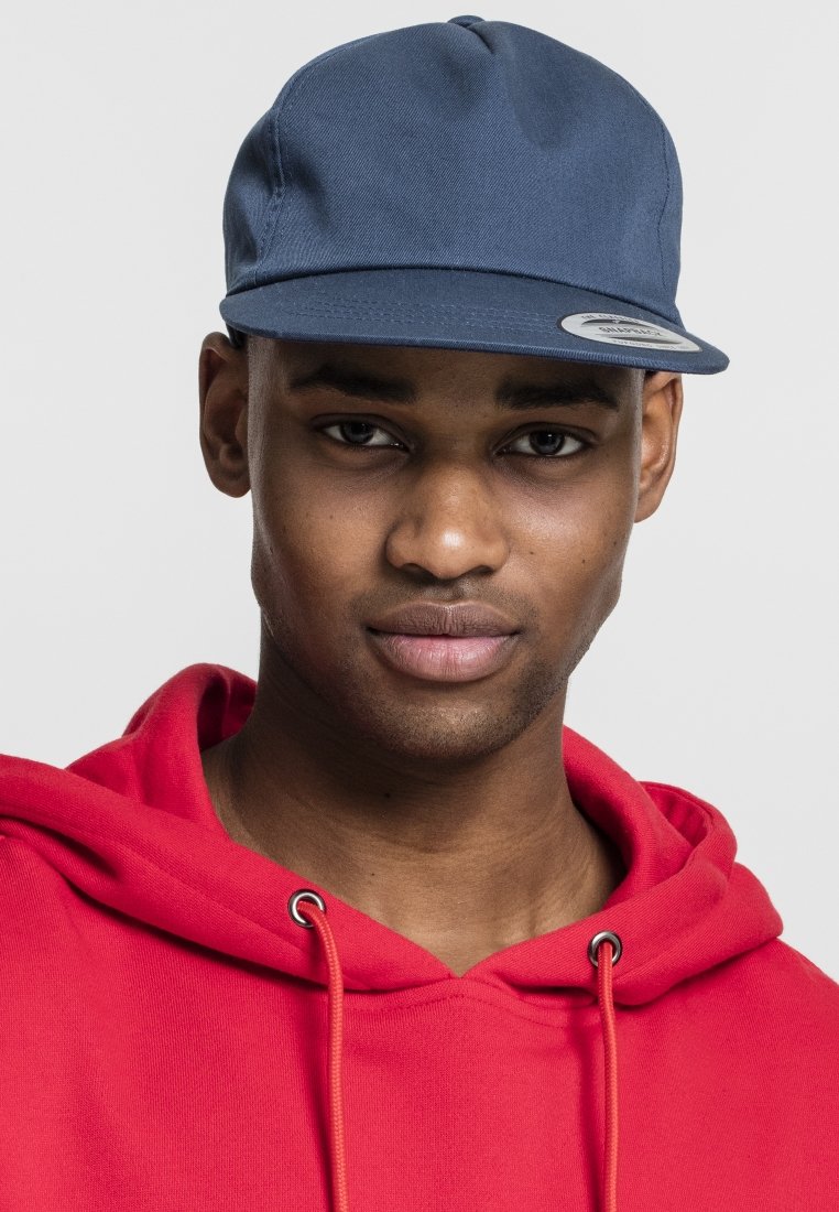 Navy blue cap with a flat brim and six-panel design, featuring a round logo sticker. Worn with a red hoodie showcasing a drawstring detail.