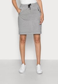Gonna grigia a motivo pied de poule con vita elastica, chiusura a cordoncino e tasche con zip, dallo stile con silhouette dritta e lunghezza al ginocchio.