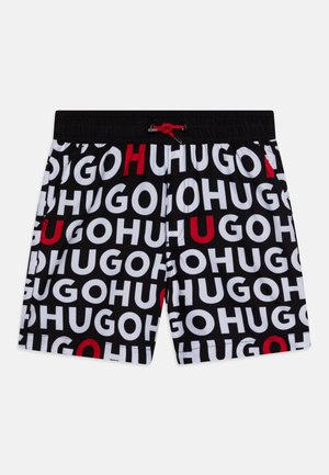 Pantaloni da bagno con una base nera e audaci motivi di testo bianchi e rossi. Vita elasticizzata con cordino rosso e tasche laterali.