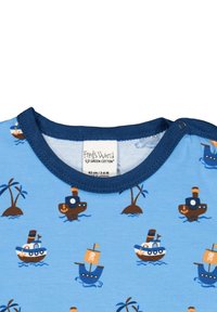 Světle modrý bavlněný overal s námořnickým potiskem lodí a palem. Námořnický modrý lem obklopuje výstřih a je opatřen patentkami.