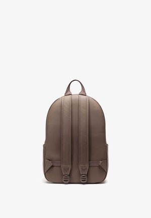 Hnědý batoh s hladkou texturou, zakřiveným vrškem, dvěma polstrovanými ramenními popruhy a bočními kapsami. Obsahuje centrální madlo na vrchu pro snadné nošení.