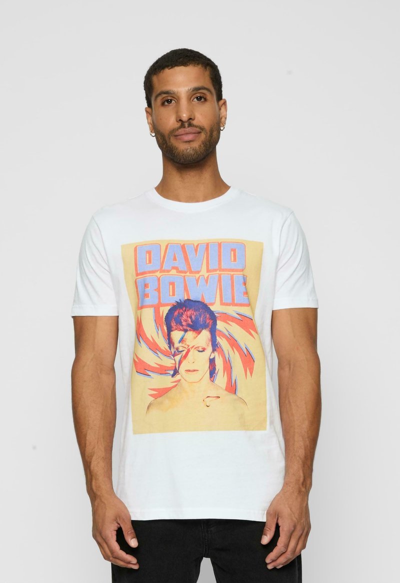 Hvid bomulds T-shirt med et grafisk tryk af David Bowie i kraftige orange og blå farver, omkranset af et svajende mønster.