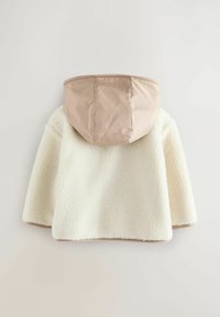 Kreemika värvi fliisjakk beeži kapuutsiga, mis on pehme tekstuuri ja ümarate vormidega, loodud soojust ja mugavust pakkuma.