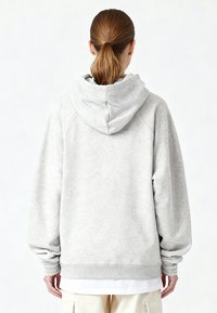 Felpa grigia chiaro con cappuccio, polsini e orlo a costine, spalle scese e tessuto liscio. Presenta un design semplice e minimalista.