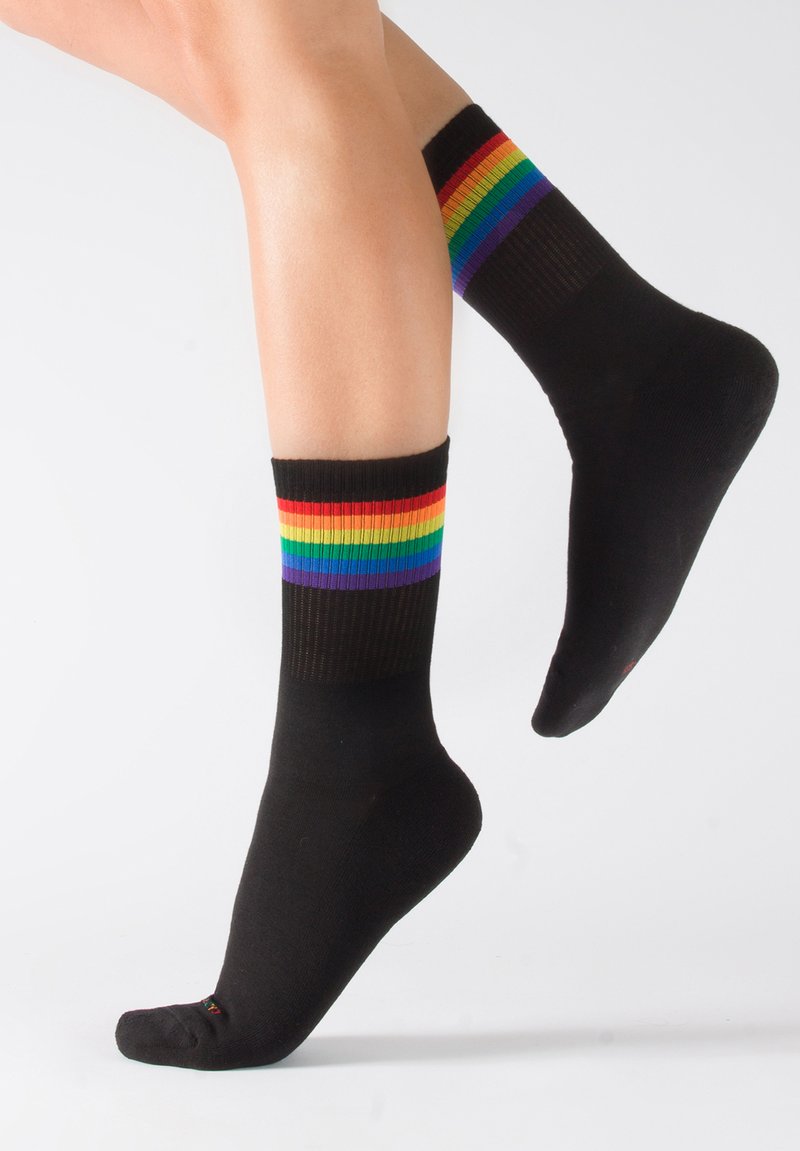Calcetines de algodón negros con puños acanalados que presentan rayas horizontales de colores del arcoíris en rojo, naranja, amarillo, verde, azul y púrpura en la parte superior.