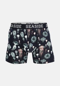 Boxer da uomo con sfondo blu navy, decorati con motivi di meduse e conchiglie colorate. Vita elastica con etichetta "SEASIDE."
