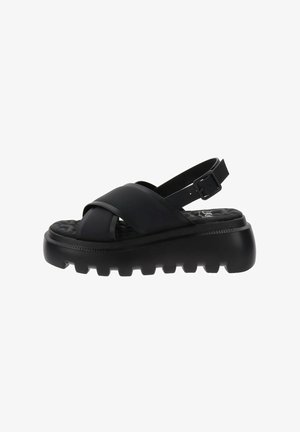 Sandales noires avec des lanières larges croisées et une boucle réglable à la cheville. Semelle épaisse et texturée avec un logo Clarks sur la semelle intérieure.