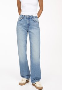Svetlo modri ravno krojeni jeans iz denima, z zmerno visokim pasom in klasičnim petim žeparjem ter rahlim bledenjem.