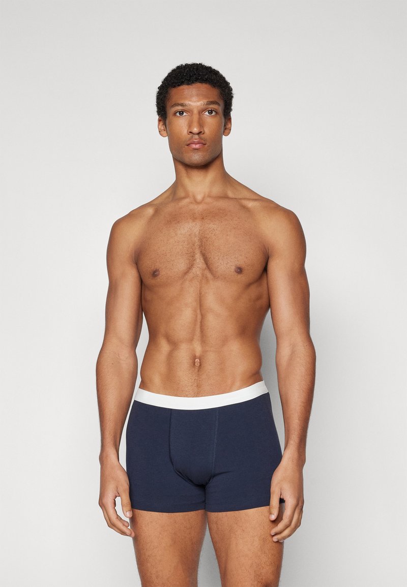 Navyblaue Boxershorts aus weichem Stoff mit einem weißen elastischen Bund. Haben ein körpernahes Design und keine auffälligen Muster.