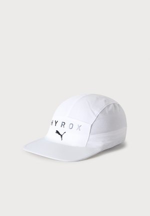Casquette de sport blanche avec le texte "HYROX" et le logo Puma à l’avant, avec une visière incurvée sur un fond clair uni.