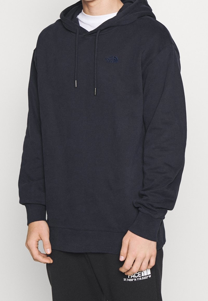 Námořnicky modrá mikina s kapucí z bavlněné směsi, s přední kapsou kangaroo, stahovací šňůrkou na kapuci a malým logem na hrudi. Měkká textura.