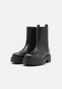 Sorte lær ankle boots med rund tå, blokkhæl og elastiske sidepaneler. Har en glat tekstur og et minimalistisk design.