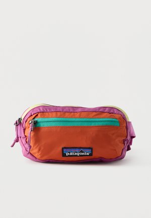 Kleine Patagonia-Gürteltasche mit orangefarbener Vorderseite, violetten Seiten, grünem Reißverschlussfach und gelbem Deckel vor weißem Hintergrund.