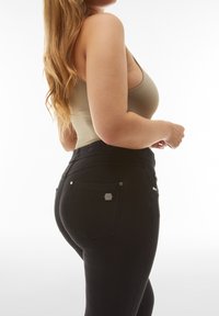 Jeans de mezclilla negra con un diseño ajustado, que cuentan con una cintura de altura media, bolsillos traseros y acentos de metal. Textura suave.
