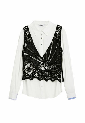 Camisa blanca de manga larga abotonada, combinada con un chaleco sin mangas de encaje de crochet negro con patrones florales y geométricos.