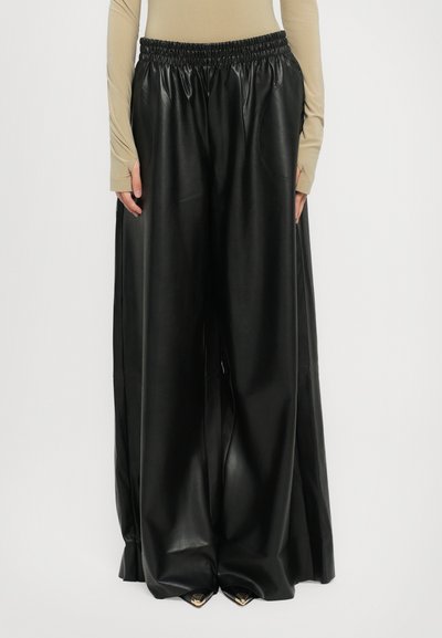 Pantalons en cuir noir à jambes larges avec une taille élastique, dotés de poches latérales et d'une texture lisse et brillante.